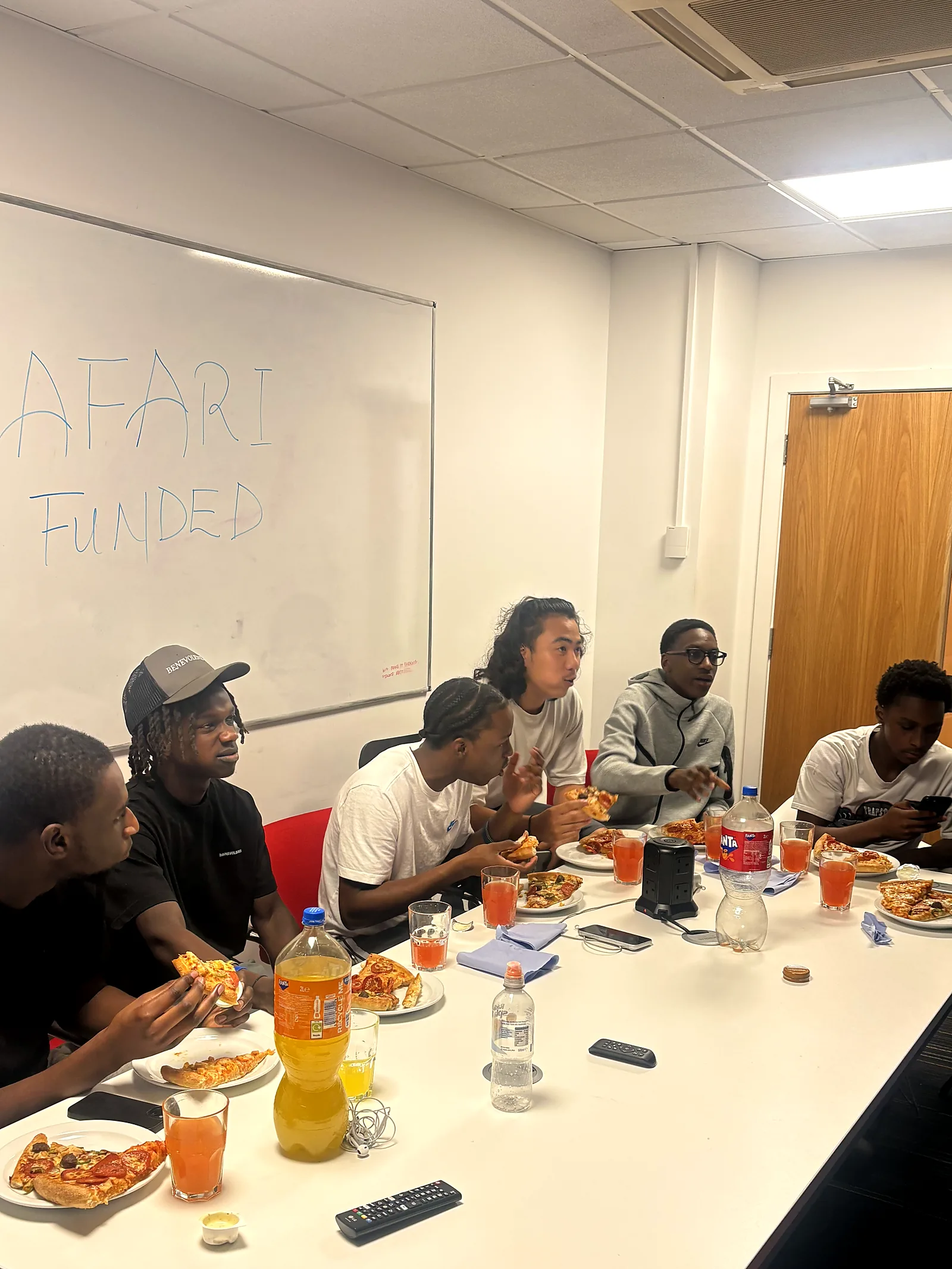 Young people eating together around a long table at a JDS session